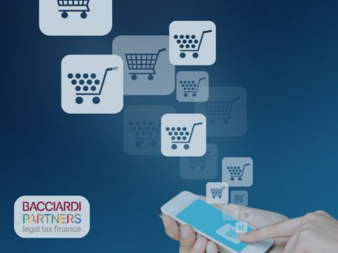 Immagine con sfondo blu, logo BP in basso a sinistra e immagine raffigurante mano che tiene il telefono in mano dal quale fuoriescono immagini di carrelli virtuali volti a significare il commercio elettronico.